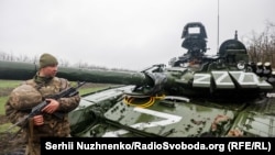 Украинский военный у поврежденного российского танка Т-72БЗ, Донецкая область, 13 апреля 2022 года