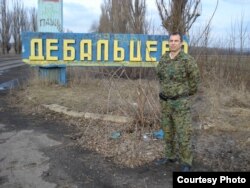 Казак Евгений Панчук у стенда названием украинского города Дебальцево, на котором можно увидеть надписи "Новосибирск", "ВДВ".