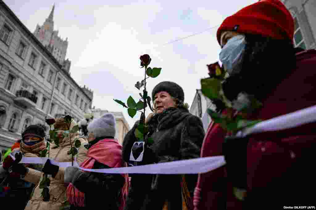 Россиянки держат цветы во время формирования живой цепи в Москве