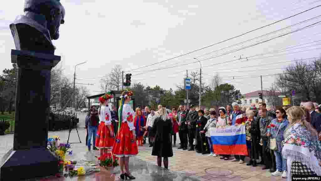 Позже началась официальная акция с участием депутатов российского горсовета Симферополя, &laquo;Русской общины Крыма&raquo; и представителей разрешенной российскими властями &laquo;Украинской общины Крыма&raquo;. Они по команде возложили красные гвоздики к пьедесталу Кобзаря